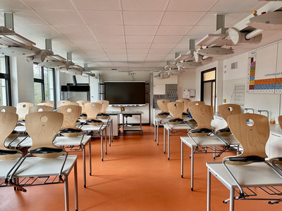 Blick auf das Fachkabinett Chemie mit Schülerbänken, Persiodensystem der Elemente an der Wand, digitalem Display vorn und technischer Ausstattung, die bei Bedarf von der Decke herabgelassen werden kann.