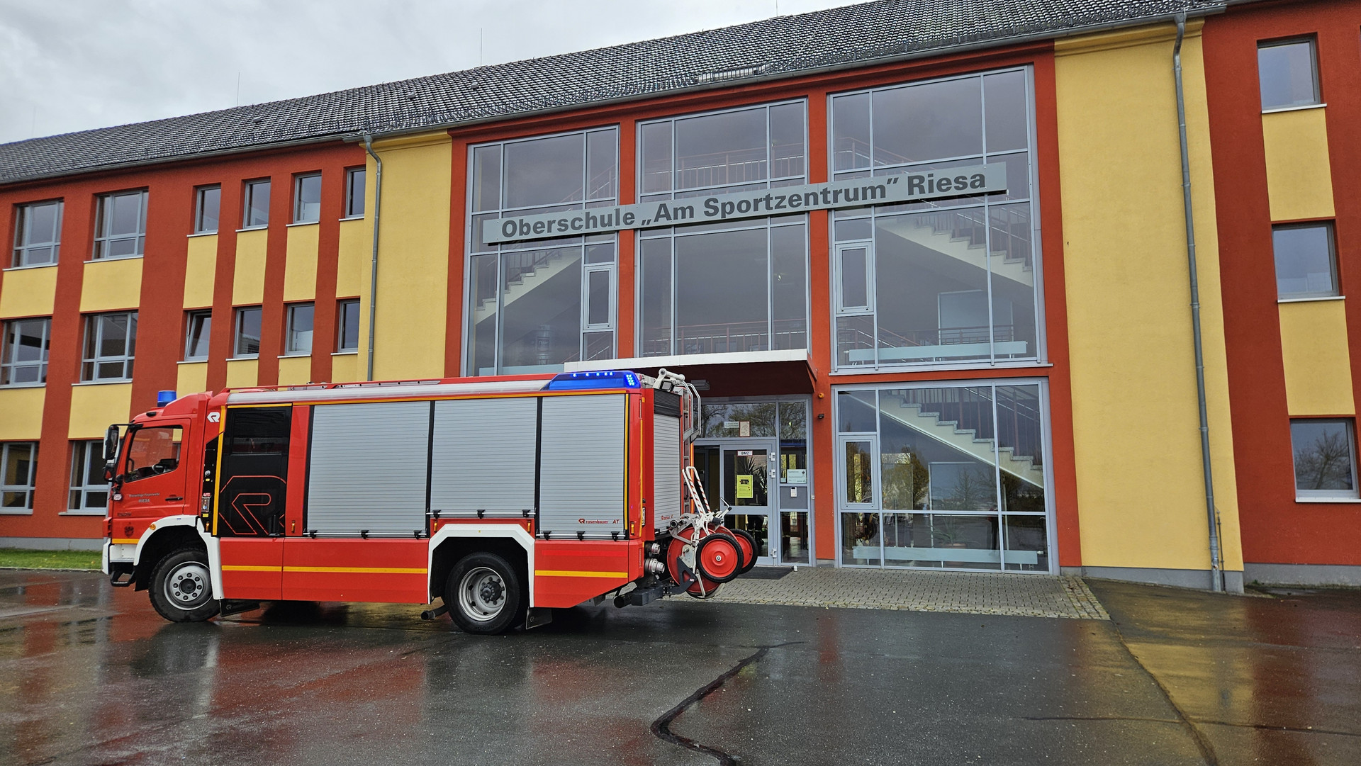 Feuerwehrauto vor dem Schulgebäude