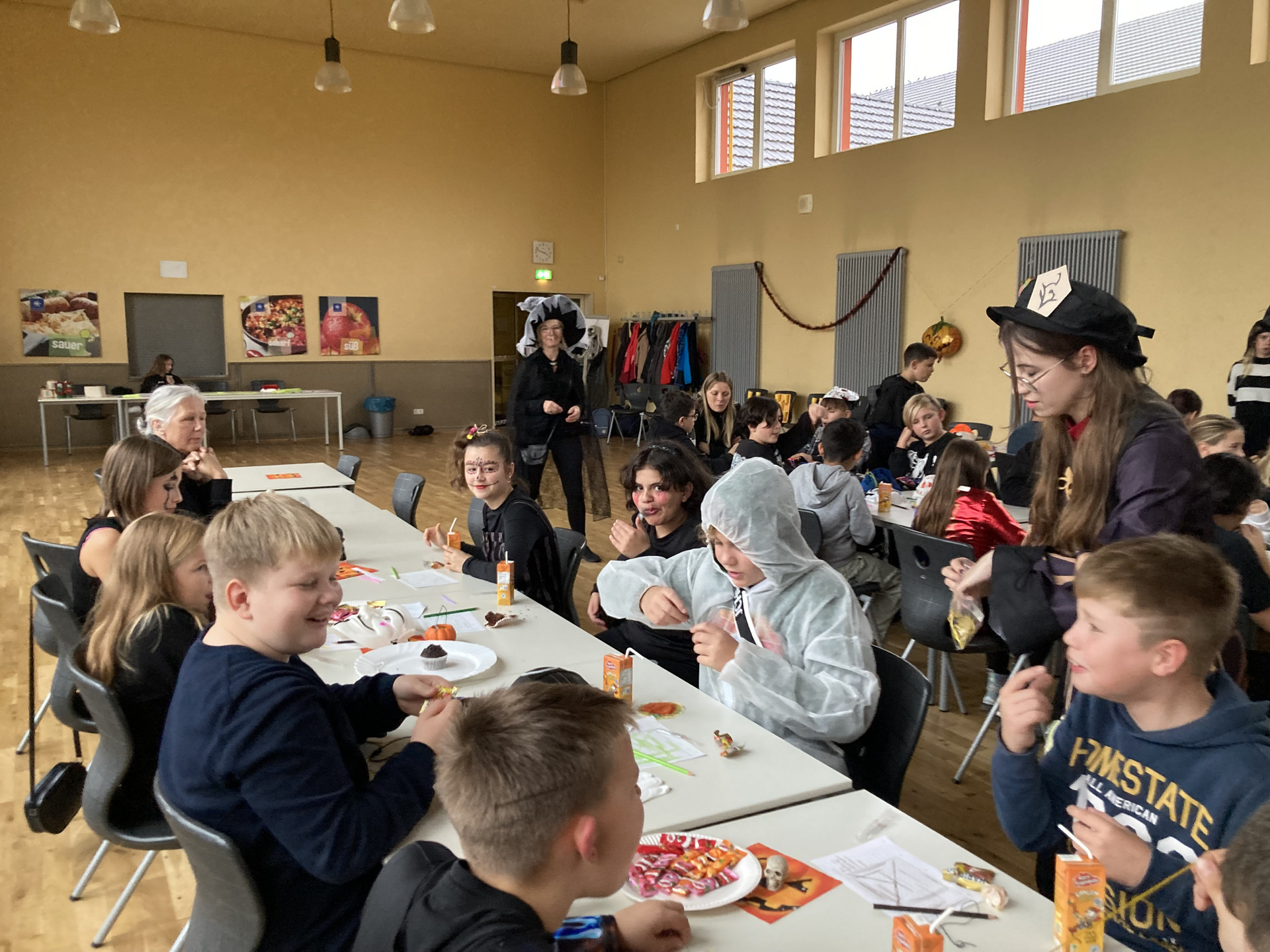 Schüler der Klassenstufe 5 mit Halloweenverkleidung am großen Tisch