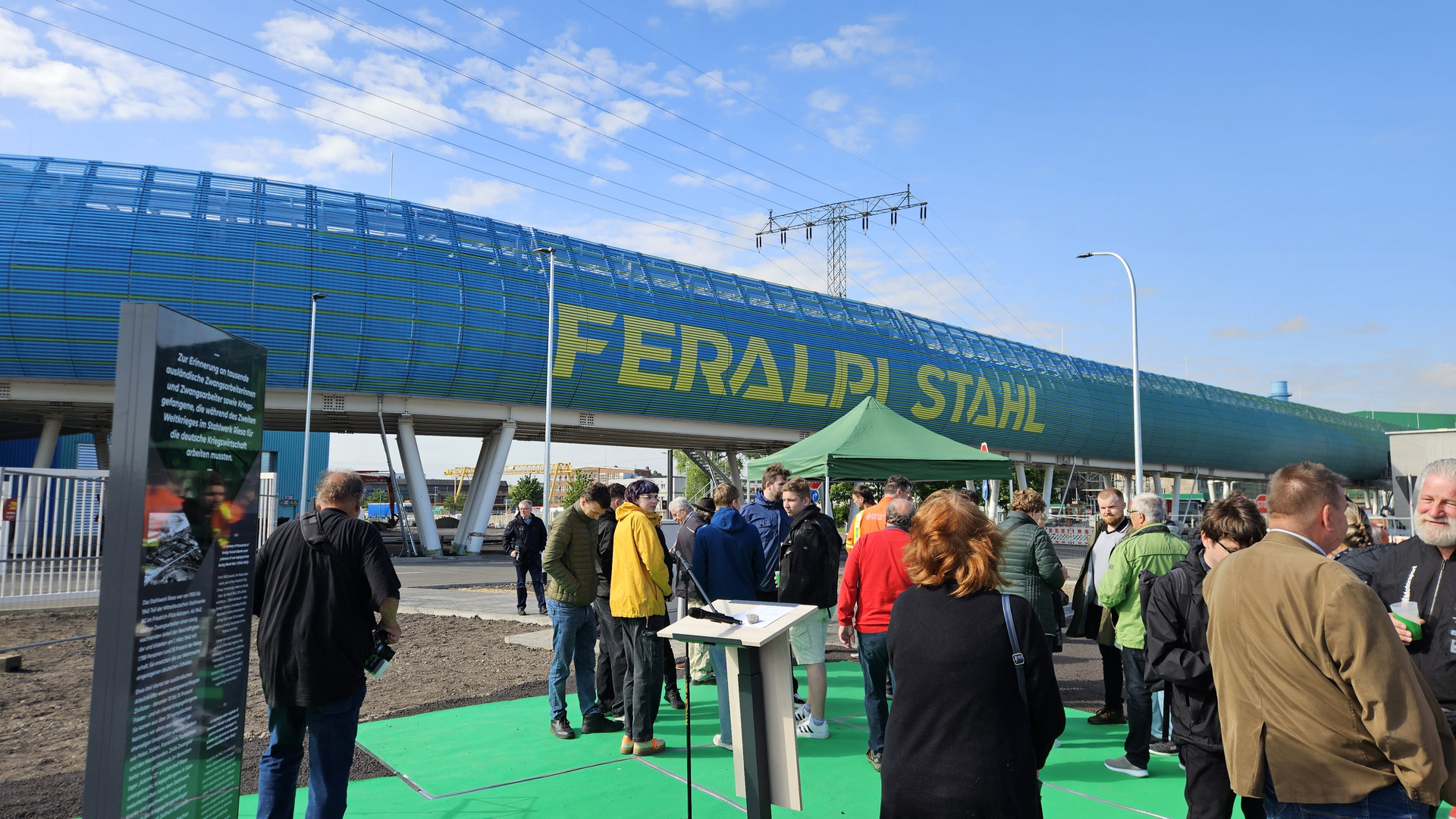 Gäste versammeln sich am Ort der Schwellenverlegung bei Feralpi