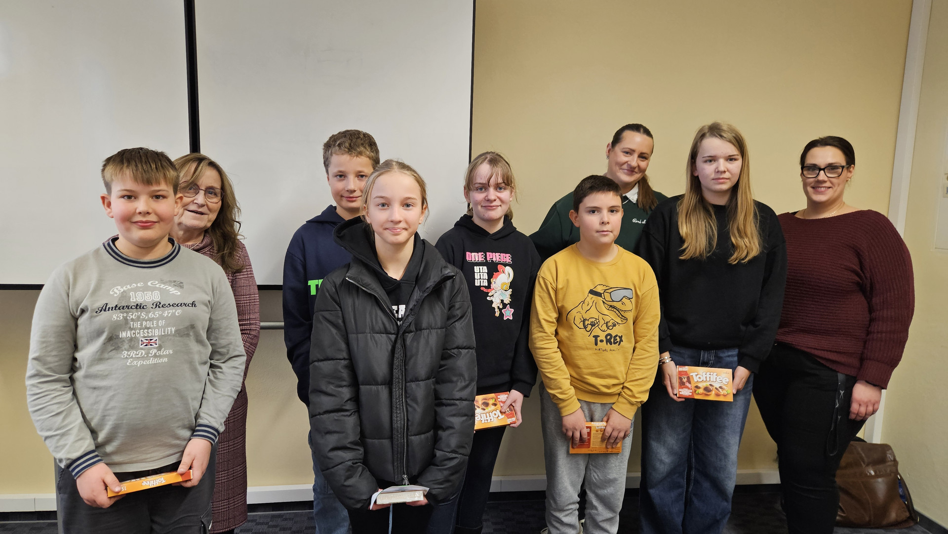 Teilnehmende und Lehrkräfte als Gruppe vor der Wand